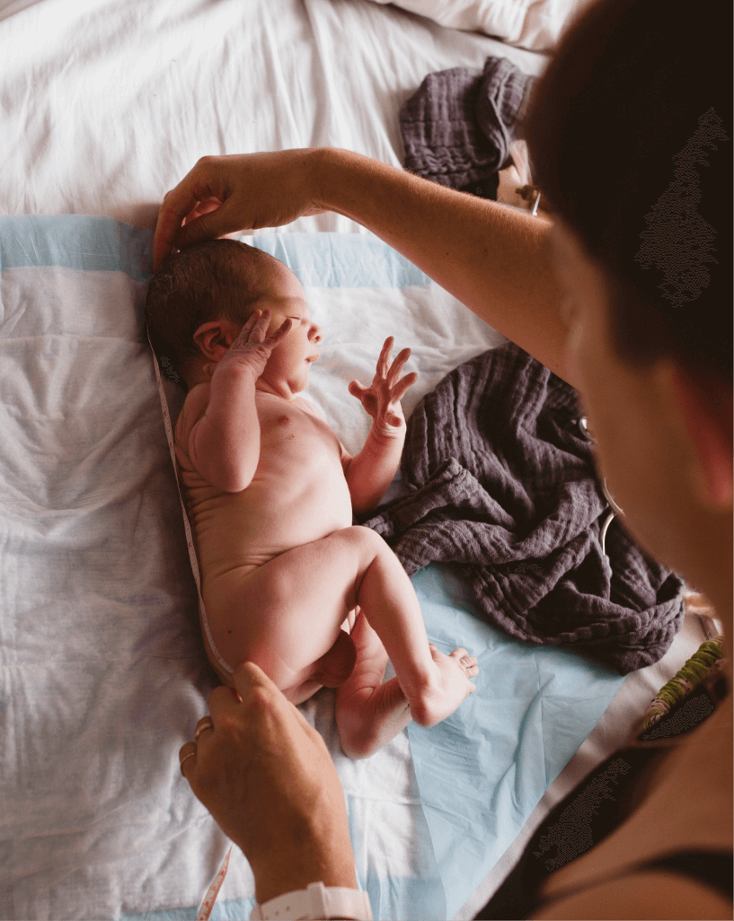 midwife measuring healthy baby birthed at home in marin county